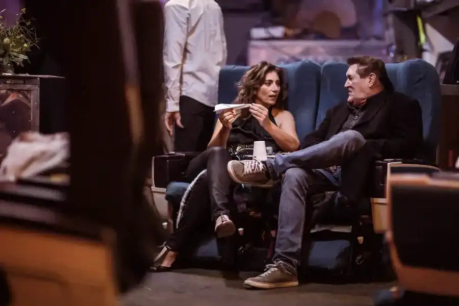 Blue upholstered theater seats with black leather trim and wooden armrests