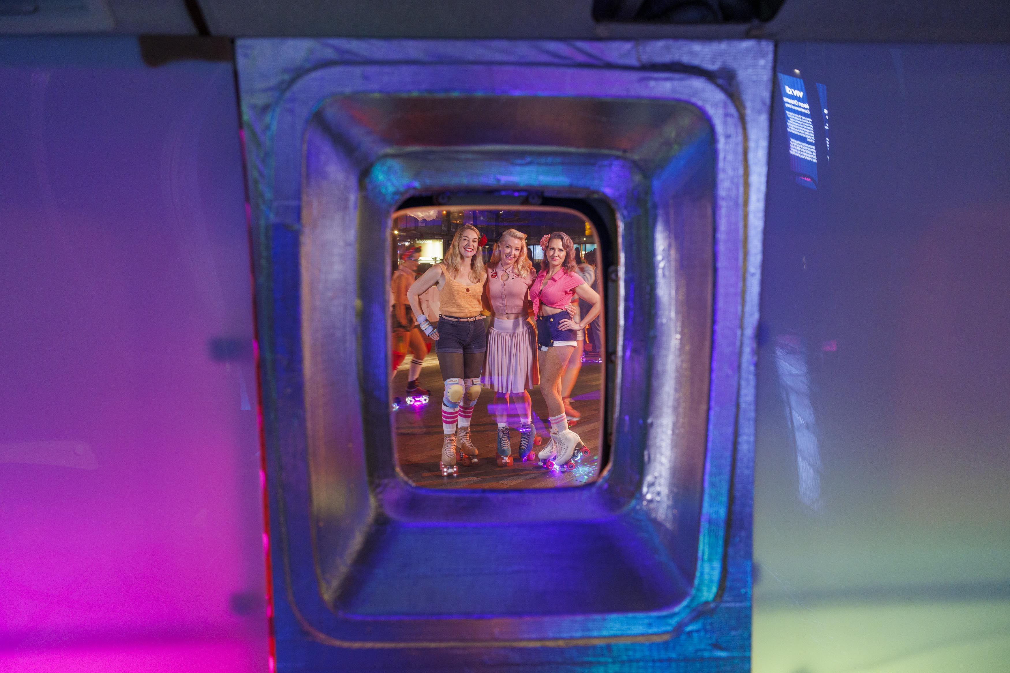 Roller skaters seen through an aircraft window at Neon Dreams during Vivid Sydney 2025