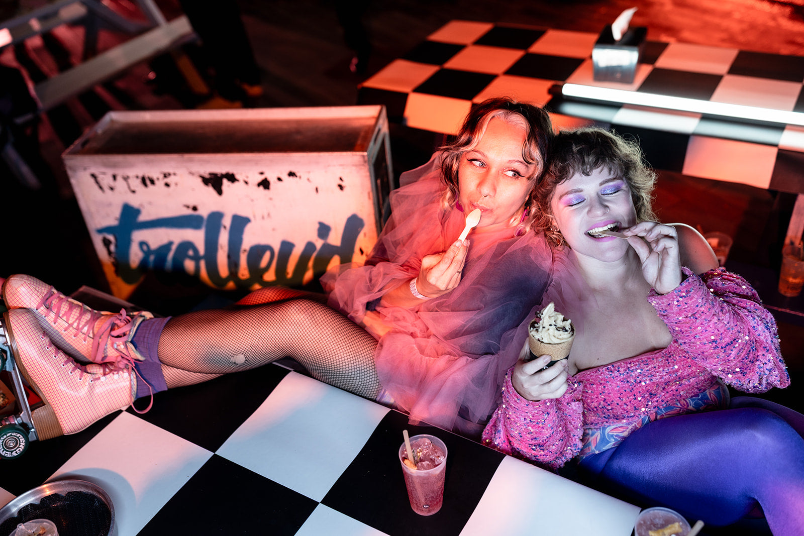 Guests enjoying food and drinks inside the Neon Dreams diner activation by Trolley’d at Vivid Sydney 2025