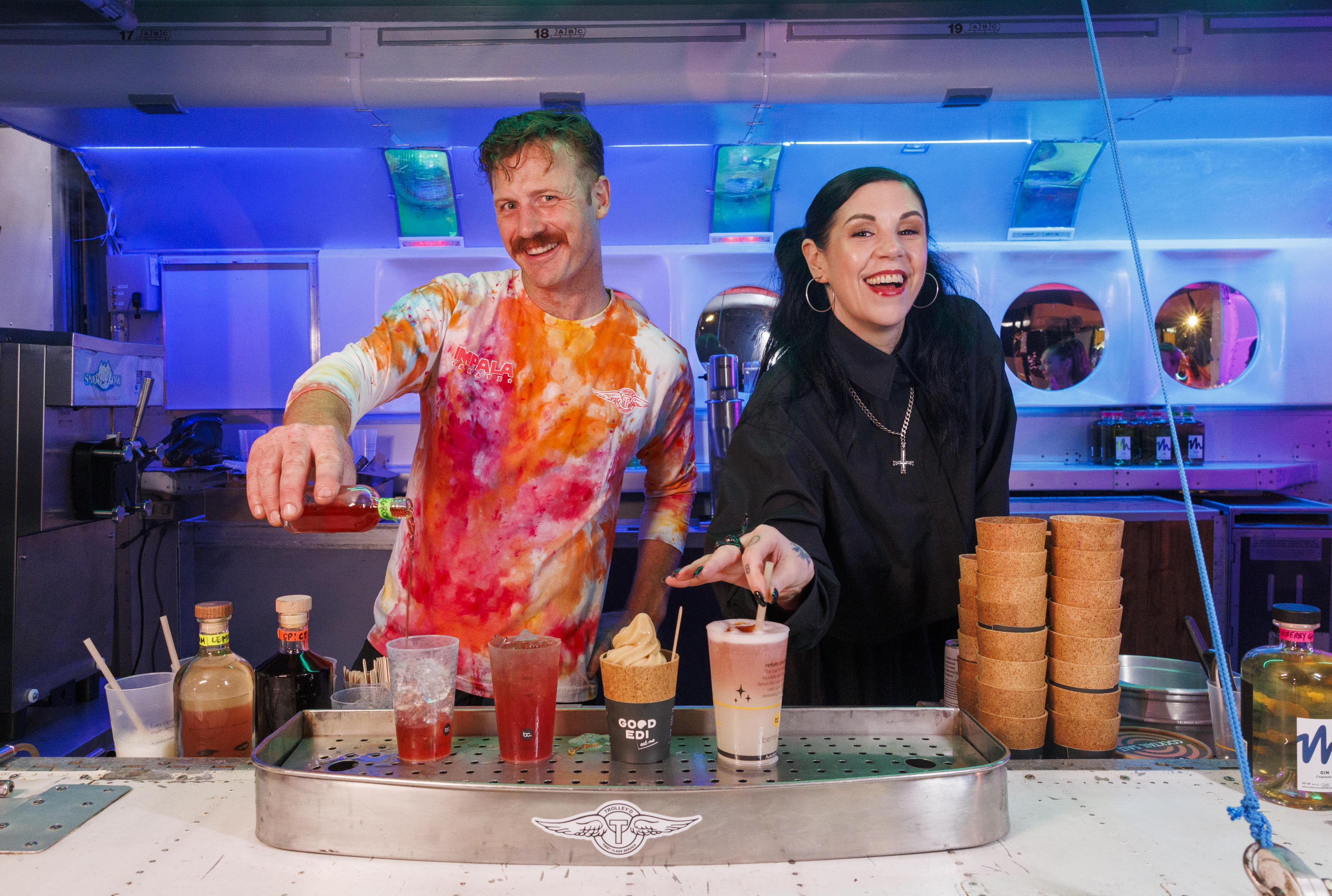 Shannon Martinez from Smith and Daughters & Byron Woolfrey from Trolley’d serving cocktails from the aircraft bar at Neon Dreams during Vivid Sydney 2025