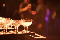 Close-up of elegant cocktails served by Trolley'd at the Australian Bartender Awards 2023, with a warm, ambient background