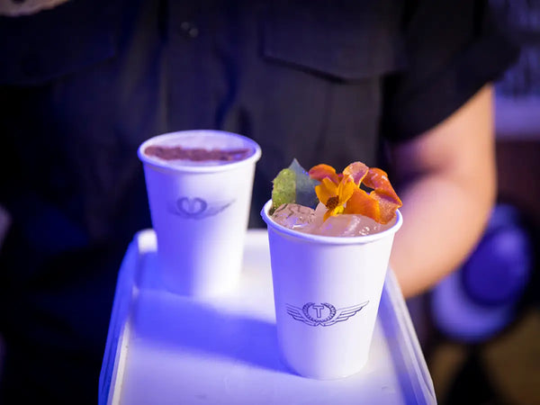 Close-up of two Trolley'd Biocups with garnished cocktails on a tray, showcasing the customizable and eco-friendly drinkware option for events.