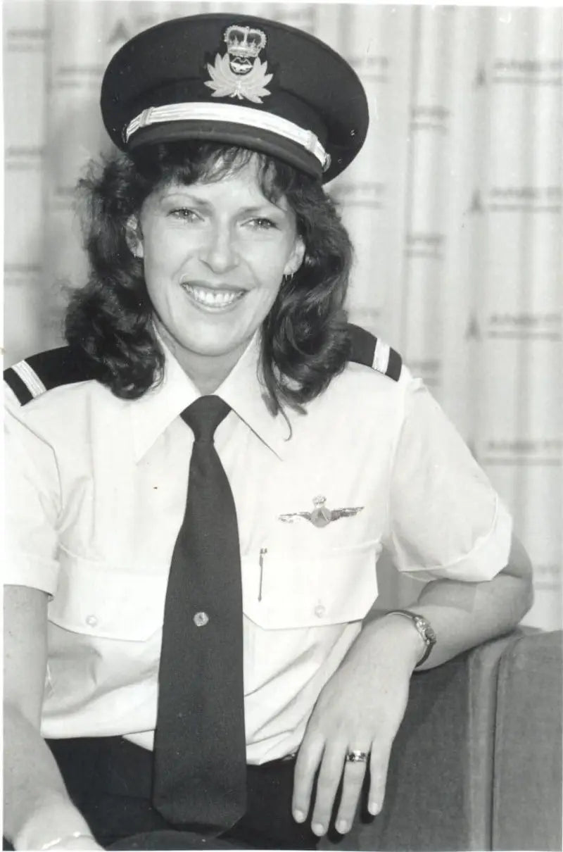 Captain Deborah Lawrie smiling in her pilot uniform with an Ansett Airlines backdrop.