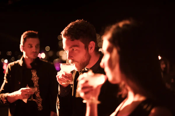 Guests savoring cocktails at the Australian Bartender Awards 2023, with warm, ambient lighting creating an intimate atmosphere