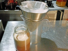 A jar of curdled milk punch and a filter setup for the separation process, ready for filtration.