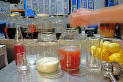 A hand stirring the milk punch mixture in a jar as part of the preparation process.