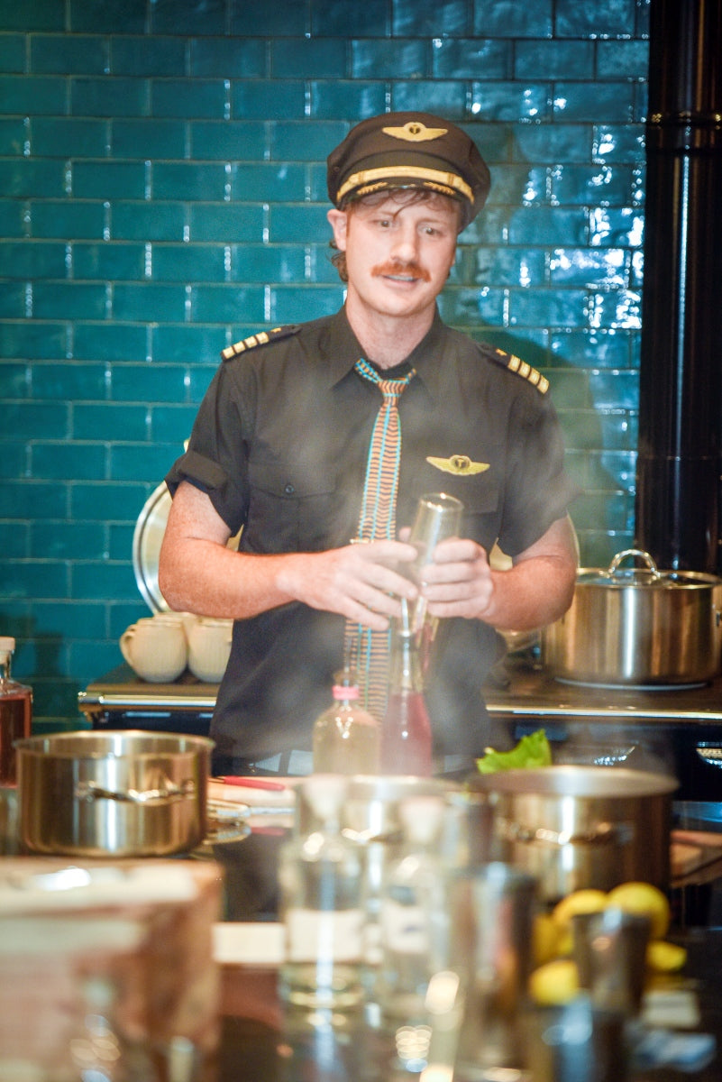 Byron Woolfrey in captain’s uniform preparing drinks at Moonacres School