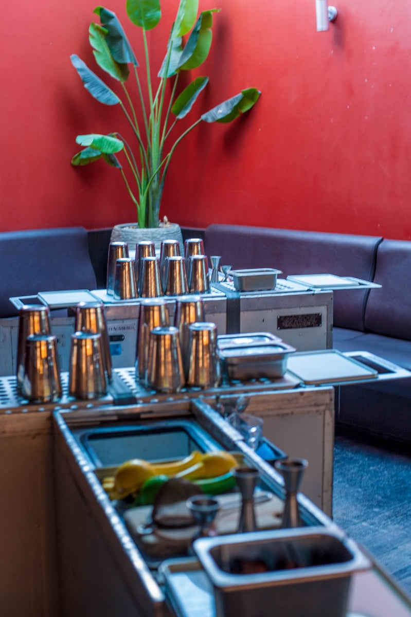 Upcycled airline trolleys laid out with cocktail shakers and mixing tools
