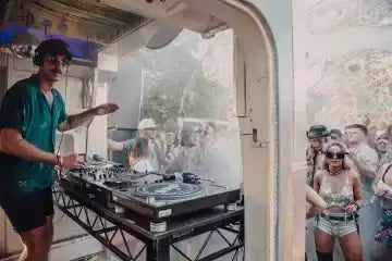 The dj’s turntables and mixer are black, sleek electronic equipment with a professional design.