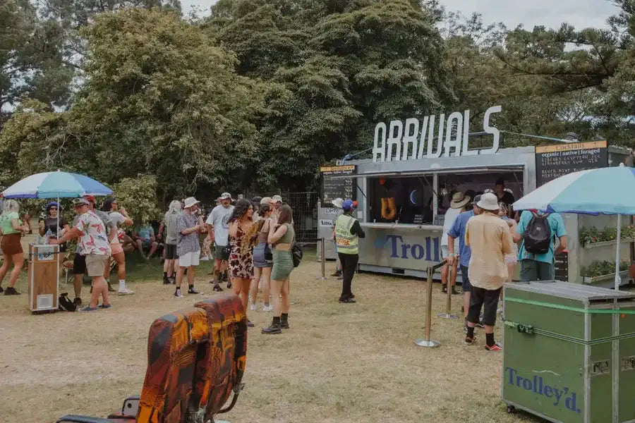 Gray metal food truck with ’arrivals’ sign and blue ’troll’ logo