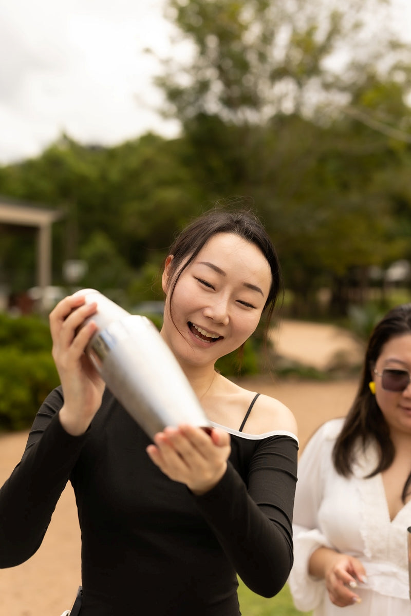 A smiling guest shaking a cocktail during an outdoor Trolley’d class in the Southern Highlands