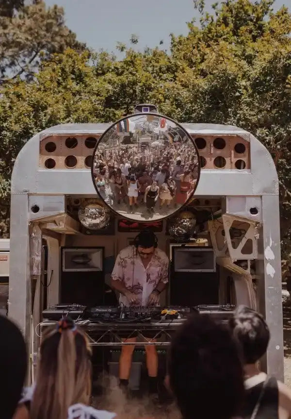 A silver, circular convex mirror mounted on a white metal trailer.