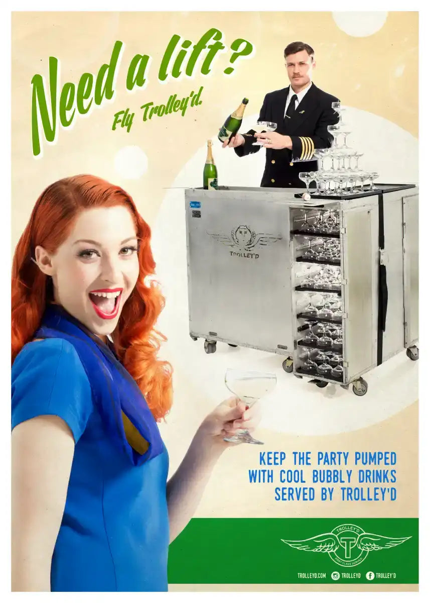 Silver metallic beverage trolley with multiple glassware compartments and wheels, branded ’trolley’d’ on its side.