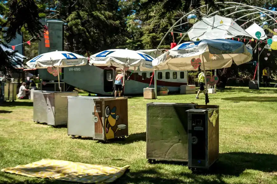 A vintage-style airplane, painted in white with red and blue accents, features a distinctive logo on its side.