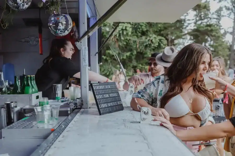 White braided bikini top with thin straps and a delicate gold pendant necklace.