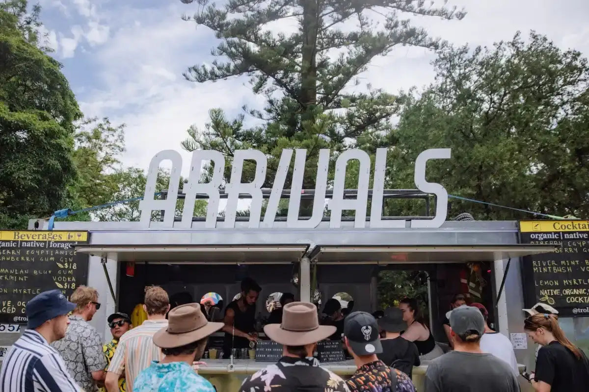 White metallic ’arrivals’ sign above a food truck.