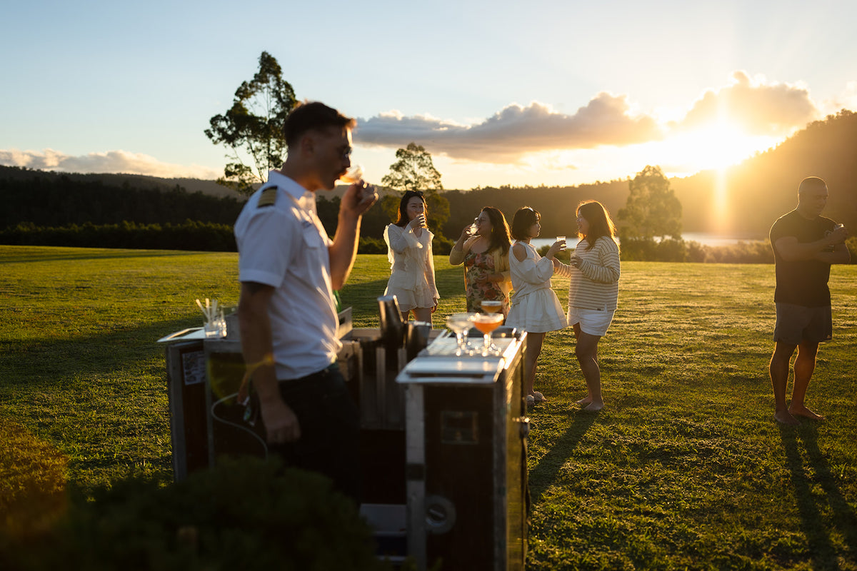 Trolley’d cocktail service on the Lake David lawn as the sun sets behind the hills